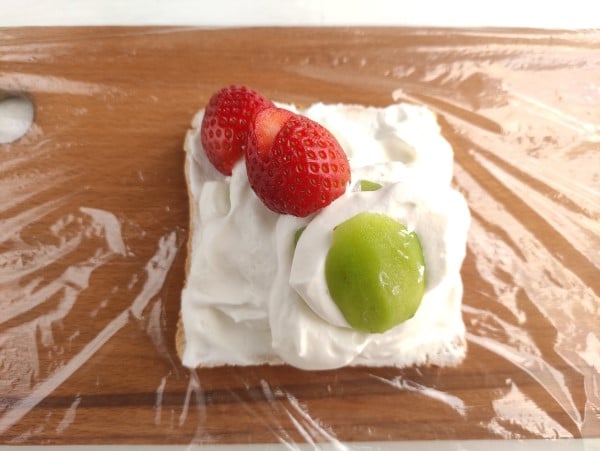 creative sandwich - more layers of strawberry and kiwi on bread with whipped cream