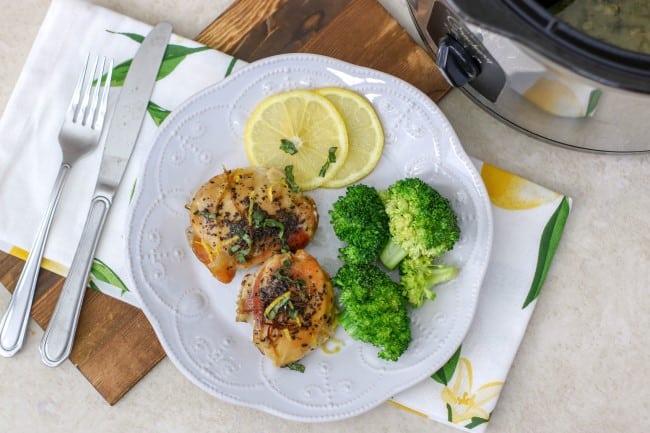 Lemon Basil Chicken Thighs - plate of chicken thighs with green brocolli on the side and slices of lemon as garnish